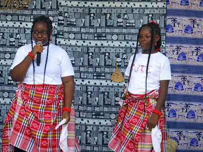 Deux élèves de la BRIF en tenue traditionnelle s’expriment devant le public lors d’une journée culturelle.