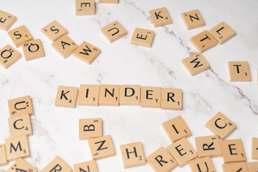 A Scrabble game with the words "Kinder" and "Saw" composed.